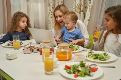 Delighted blonde woman playing with her children