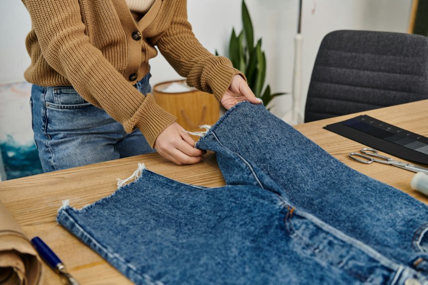 O femeie reciclează în mod creativ blugii din denim.