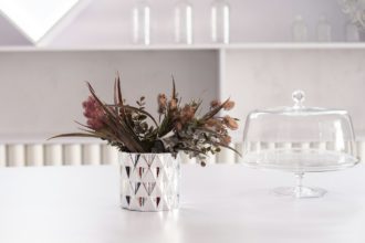 Vază cu figuri geometrice în oglindă și un buchet de flori artificiale